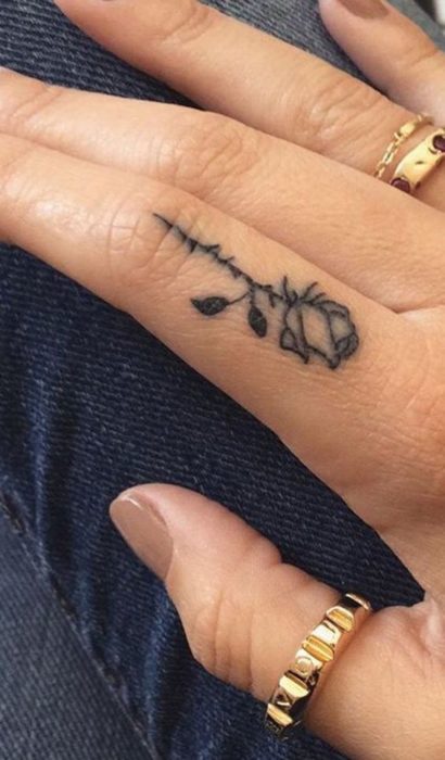 Tatuaje pequeño de una rosa en el dedo