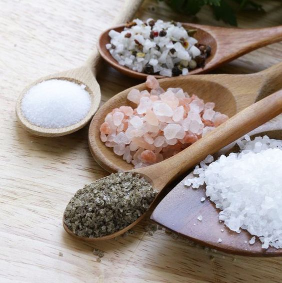 Sal rosada, negra y blanca en cucharadas de madera
