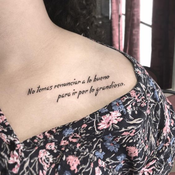 Tatuaje con frase inspiradora en las clavículas