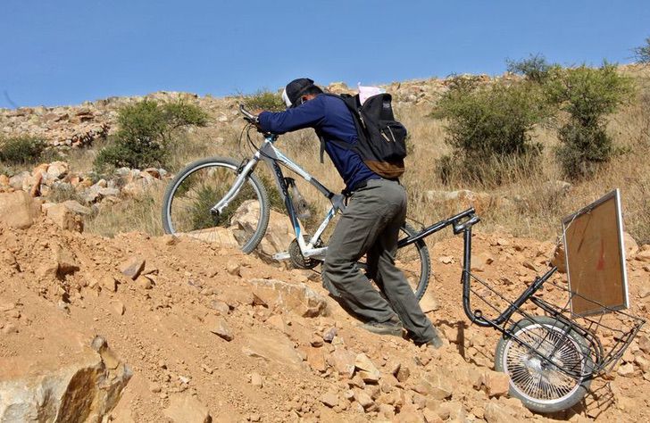 Profesor de Bolivia acompañado de su bicicleta yendo a dar clases a una comunidad indígena