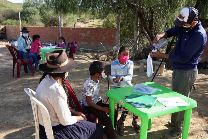 Profesor dando clases a una comunidad indígena en medio de la pandemia