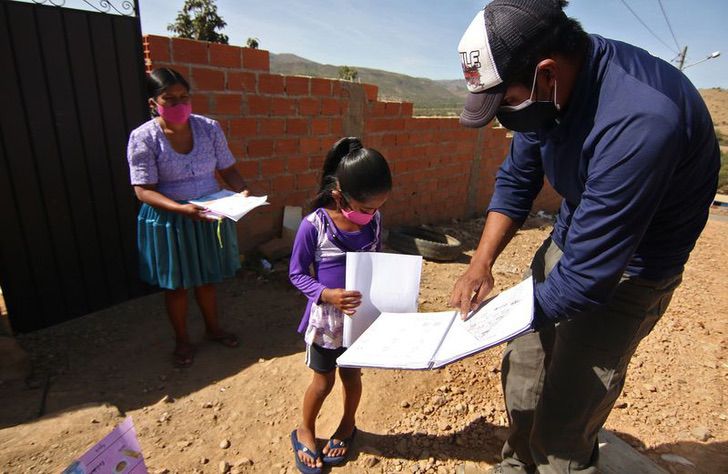 Maestro enseñando a una de sus alumnas indígenas en una comunidad
