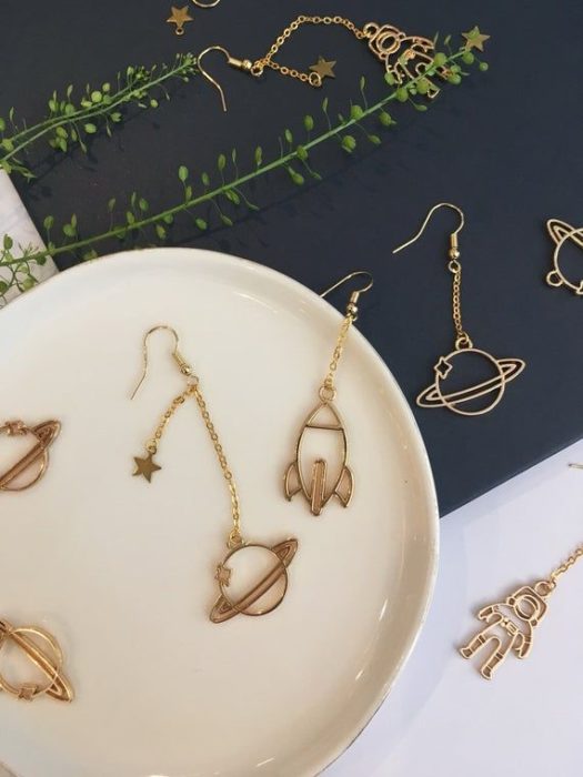 Aretes inspirados en el universo color dorado, largos con cohetes y planetas