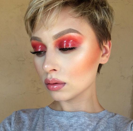 Chica rubia de cabello corto pixie con maquillaje de ojos efecto glossy color naranja