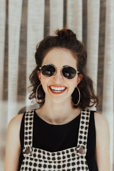 Chica sonriendo usando gafas de sol