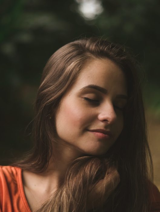 Chica con los ojos cerrados y sonriendo