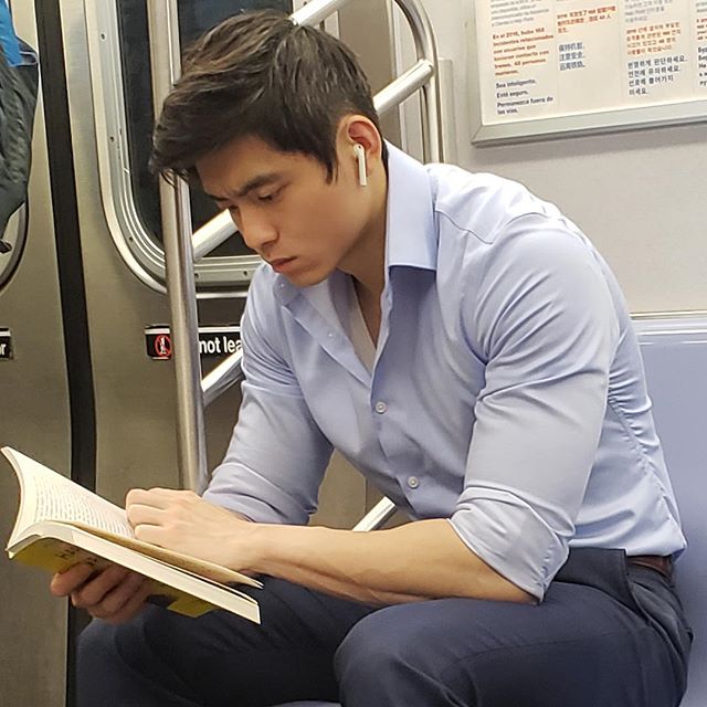 Hombre con rasgos asiáticos leyendo dentro del metro