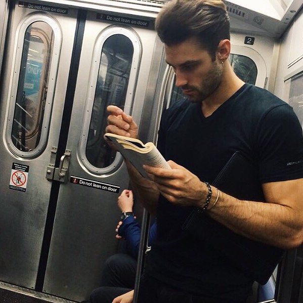 Hombre con camisa negra concentrado leyendo un libro