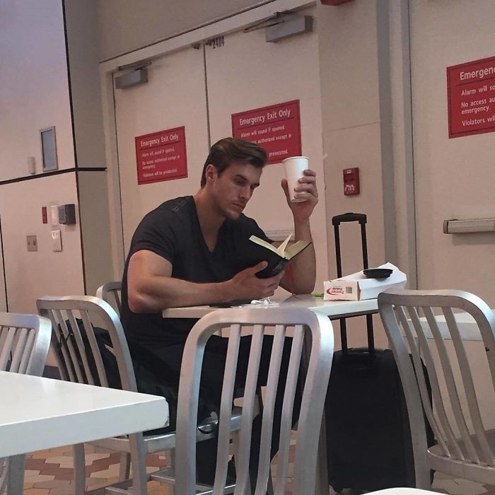 Enfermero con traje negro tomando su almuerzo y leyendo