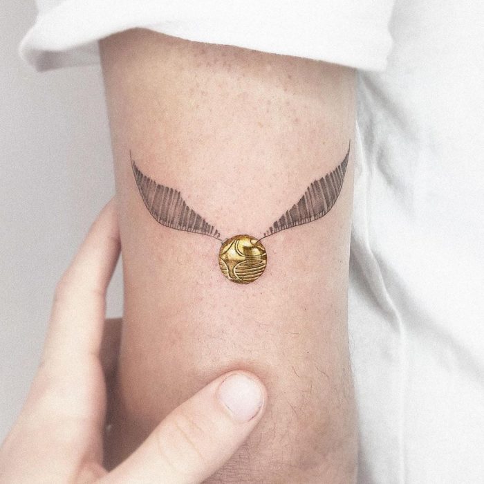 Tatuaje inspirado en Harry Potter, con la snitch dorada