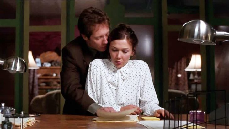 Escena de la película Secretary con Maggie Gyllenhal llevando camisa blanca con puntos negros