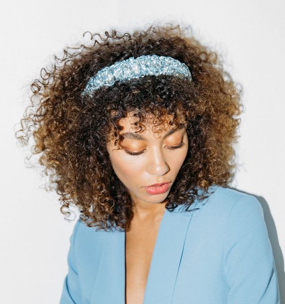 Chica morena de cabello corto y rizado con una diadema