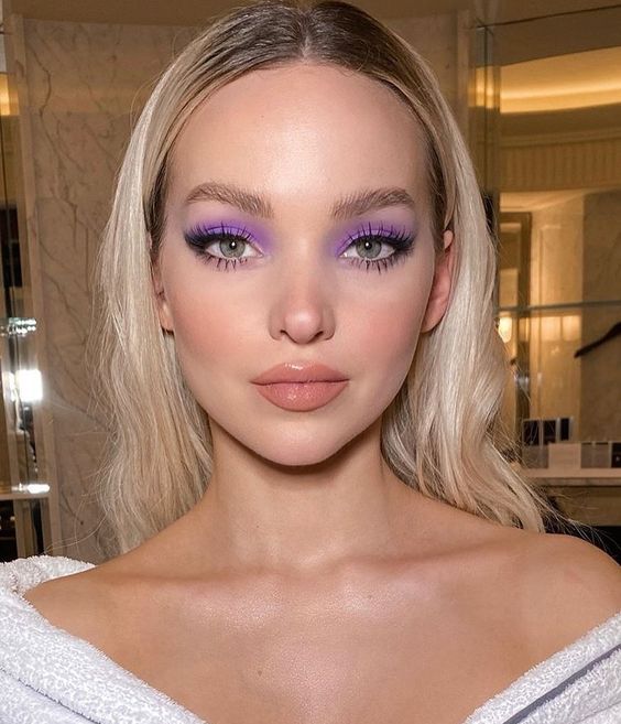 Modelo rubia de cabello largo con sombra de ojos morada