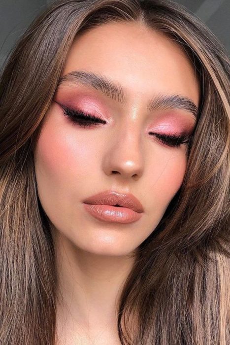 Modelo de cabello castaño usando sombras rosas