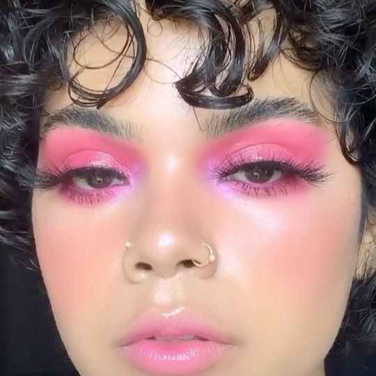 Chica morena de cabello rizado usando sombras rosas
