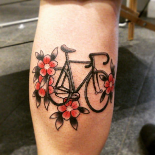 Chica con un tatuaje en el brazo de una bicicleta con flores