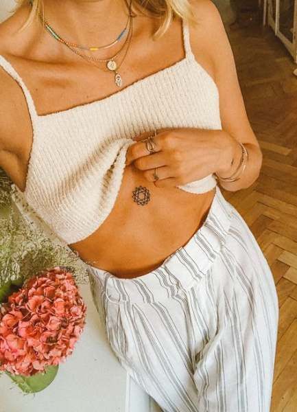 Tatuaje de mandala debajo del pecho de una mujer