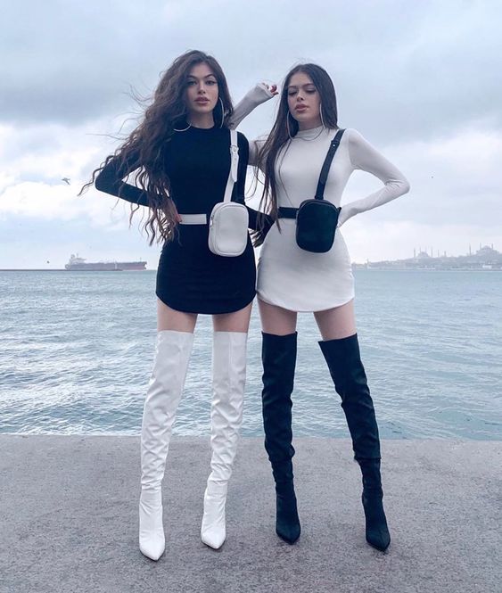 Mejores amigas con outfits iguales de vestidos negro y blanco con botas largas