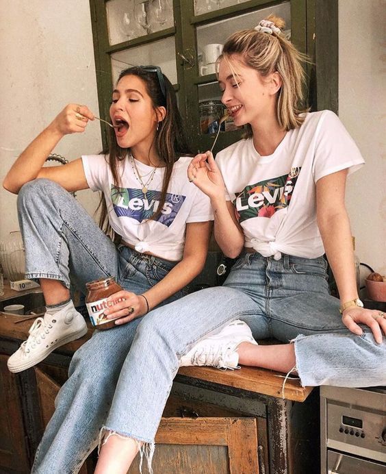 Mejores amigas con outfits iguales de blusa levis blanca con jeans