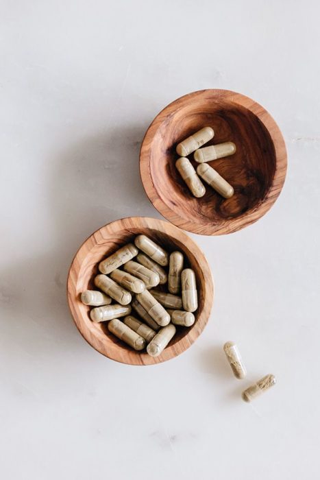 Cápsulas de medicamento en bowls de bambú