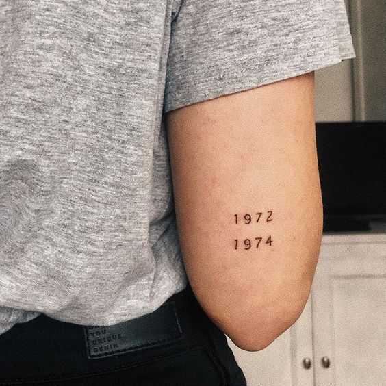 Tatuaje con años de nacimiento en tono negro