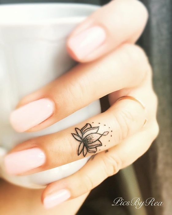 Chica con un tatuaje de una mandala en su dedo medio