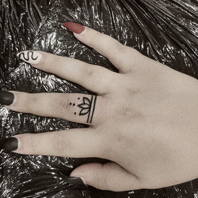 Chica con un tatuaje de una mandala en su dedo medio