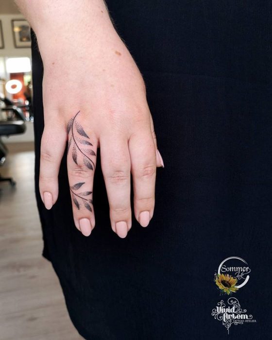 Chica con un tatuaje de olas que va desde la punta de su dedo medio hasta la muñeca