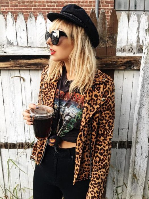 Chica rubia con gorro negro, saco de animal print y blusa negra