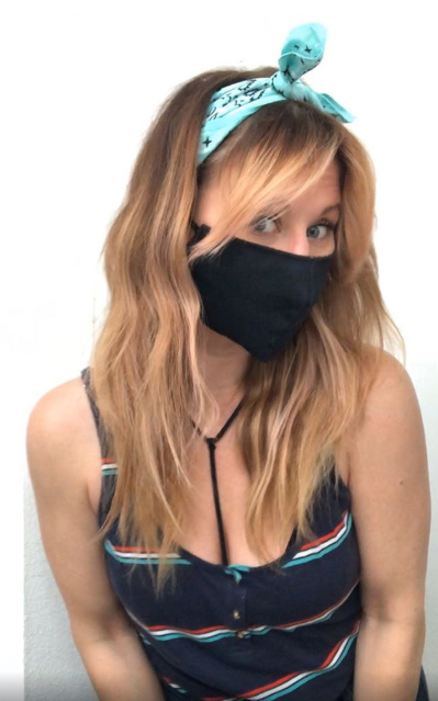 Chica usando una mascarilla sujetada con una bandana