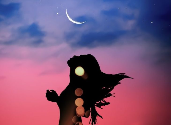Chica moviendo su cabello a contraluz y la luna de fondo