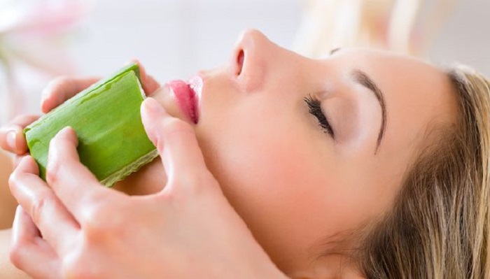 Chica aplicándose aloe vera natural en el rostro