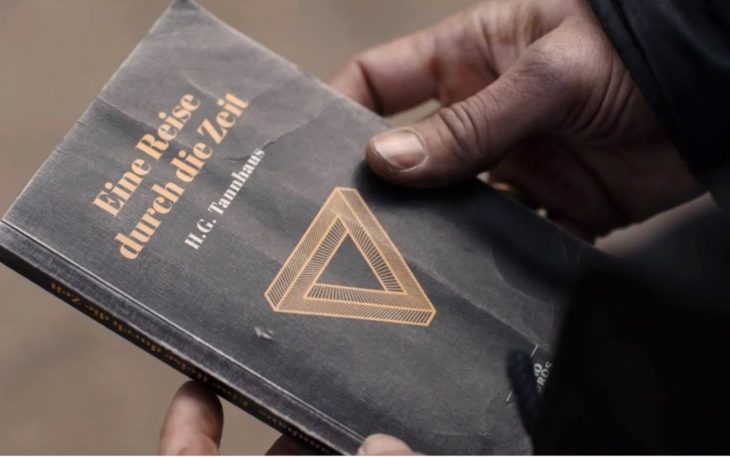 Escena de la serie Dark con Claudia Tiedemann llevando el libro de Tanhaus al pasado