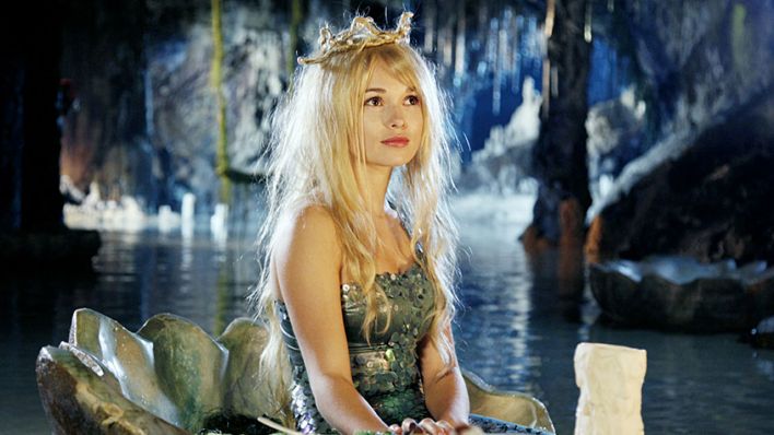 Escena de la película alemana Die kleine Meerjungfrau, una sirena debajo de una cueva con una corona de perlas