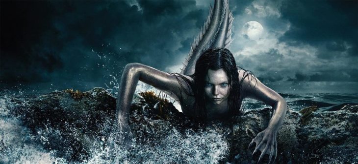 Escena de la serie Siren con una sirena saliendo del mar en medio de la noche