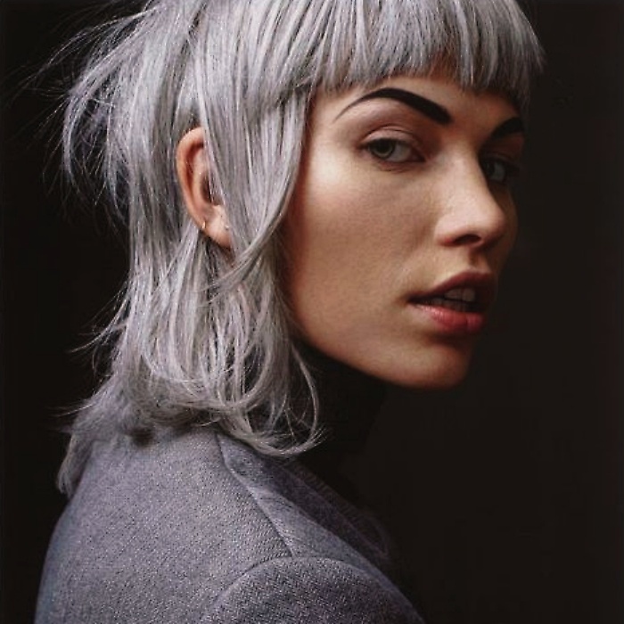 chica morena con cabello color plateado o gris, con fleco
