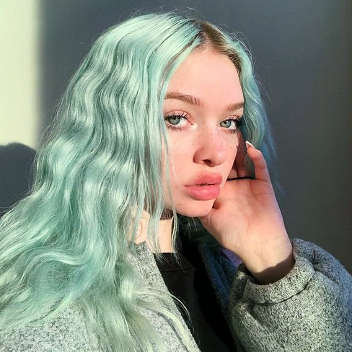 chica con cabello largo ondulado teñido en color menta o mint green hair 