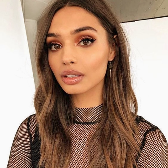 chica morena con cabello largo teñido en color castaño claro con luces