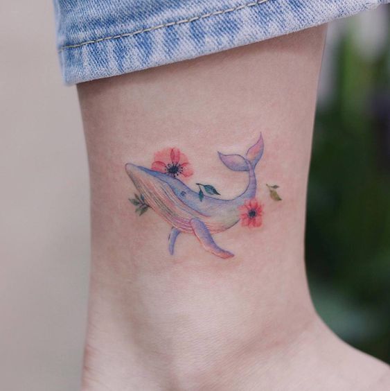 Tatuaje de ballena con efecto acuarela en tonos pastel