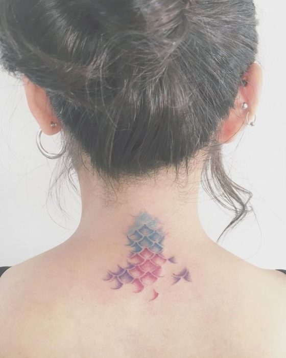 Tatuaje de escamas de sirena en tonos verde, azul y morado