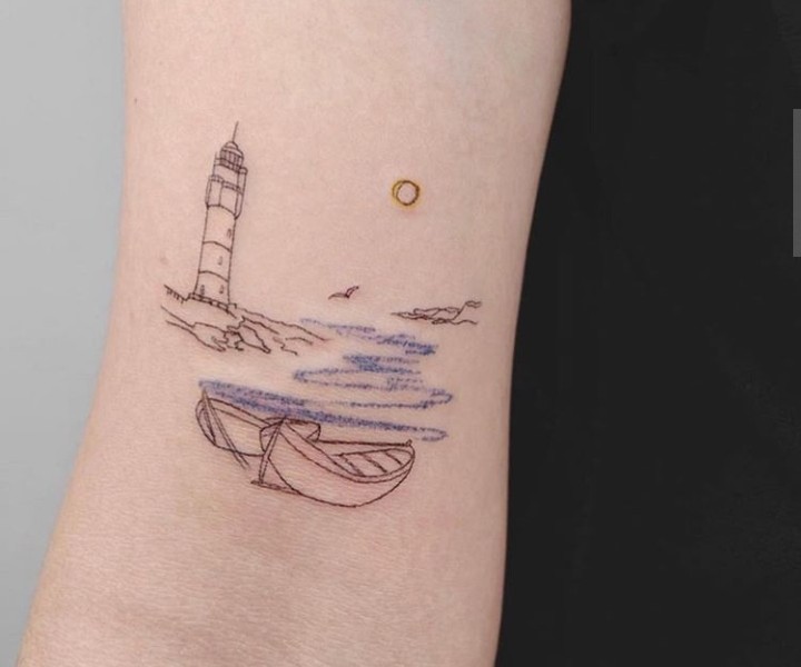 Tatuaje de un bote navegando sobre las olas hacia un faro