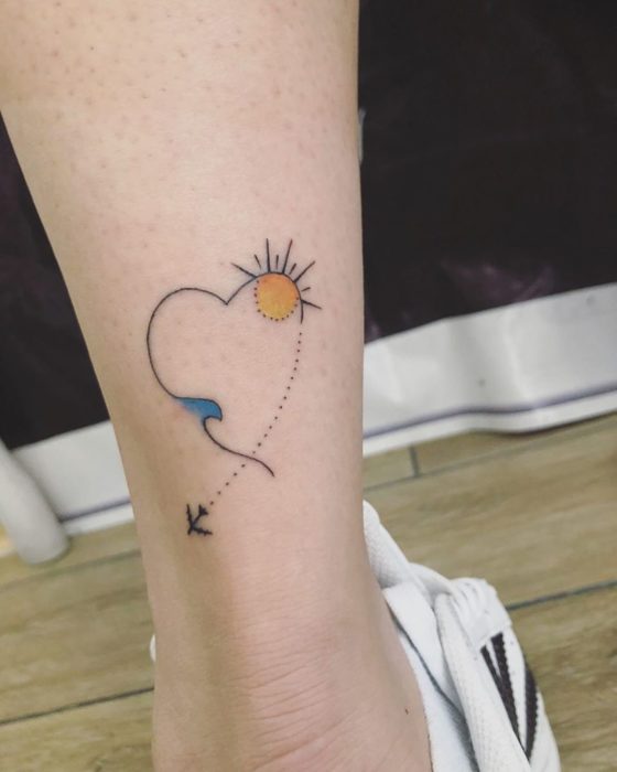 Tatuaje en forma de corazón de un avión volando hacia la playa