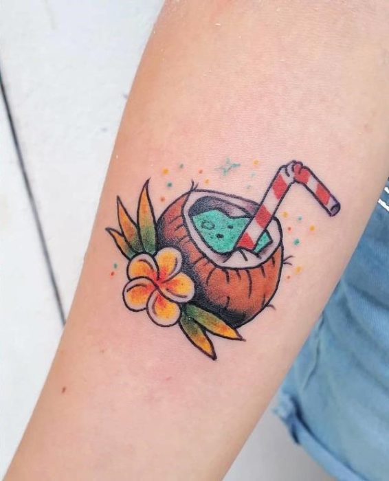 Tatuaje de una bebida de coco natural adornada con flores