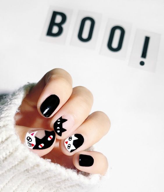 Manicura con uñas negras y decorado de gatos en color blanco