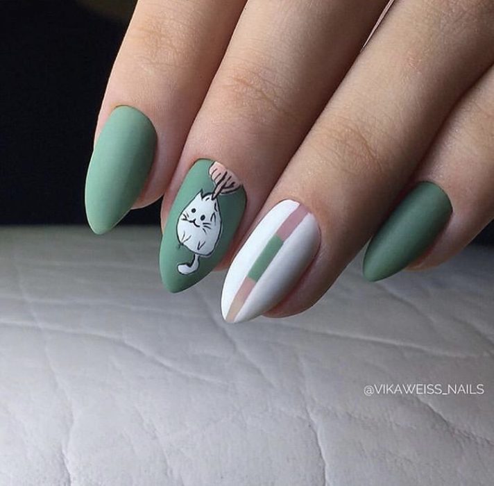 Manicura en color verde con decorado de gato en blanco y franjas blancas