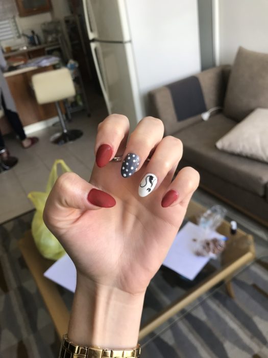 Manicura en tonos rojo, blanco y negro con decorado de gatos