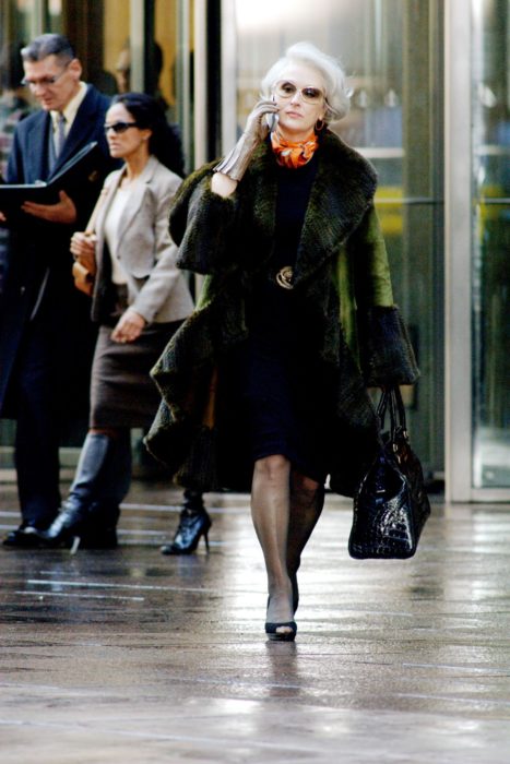 Escena de la película El Diablo Viste a la moda. Miranda caminando por las calles mientras usa un abrigo de color verde