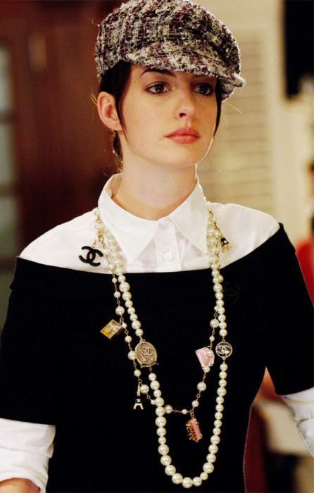 Escena de la película El Diablo Viste a la moda. Andrea usando un suéter de color negro con una blusa blanca y un collar de Chanel