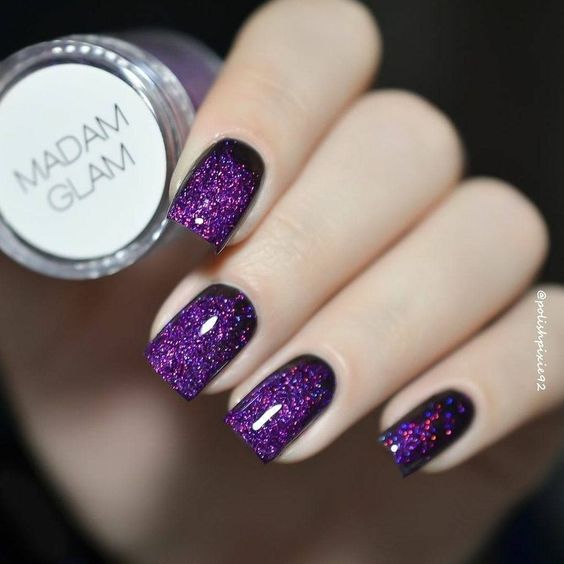 manos de mujer con manicura en tono púrpura con efecto glitter