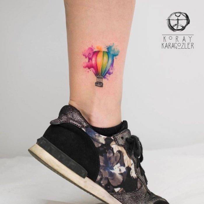 Tatuaje de globo aerostático con tonos de colores arcoíris